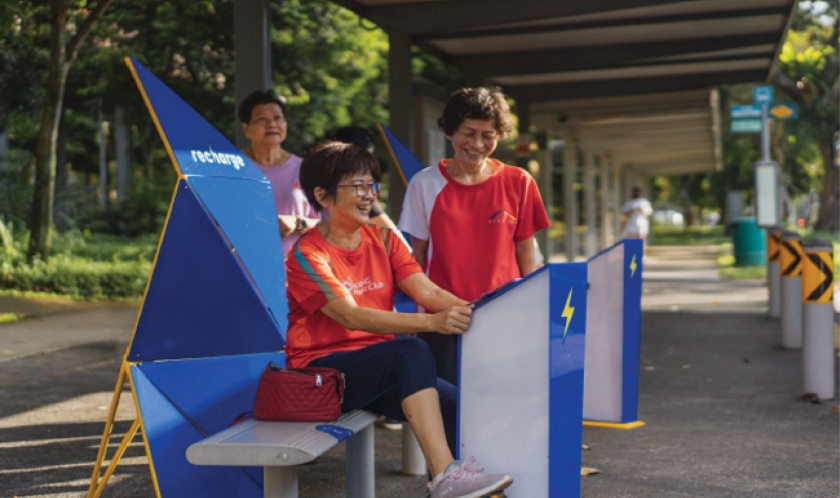 Image of ladies sittingat the bus stop shelter for Project Recharge