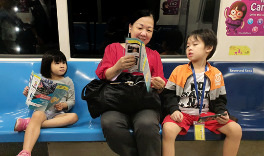 Fostering Partnership: Commuter reading our Security Guide and educating her children during one of the Citizen On Train Patrol session