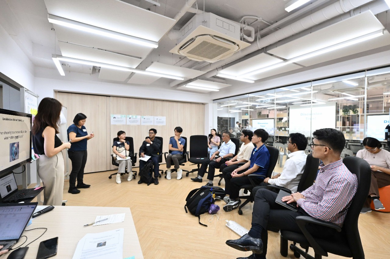 Image of MOS Baey sitting with participants in a small group discussion