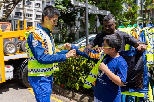 Image of young FOLT paricipant tryng on a LTA's traffic marshal vest