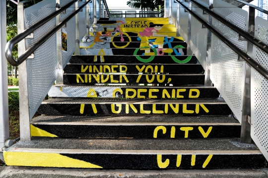 Image of a placemaking mural painting on the stairs of a overhead bridge